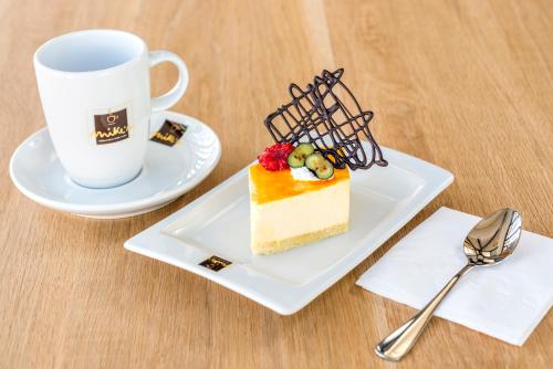 a piece of cake on a plate next to a coffee cup at El Beso Adults Only at Ocean Riviera Paradise All Inclusive in Playa del Carmen
