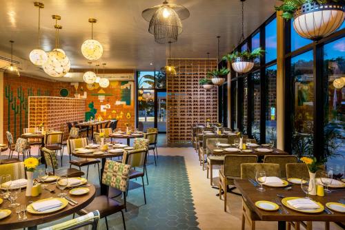 a restaurant with wooden tables and chairs and windows at El Beso Adults Only at Ocean Riviera Paradise All Inclusive in Playa del Carmen