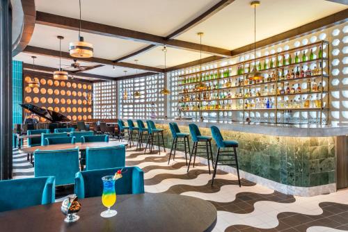 a restaurant with blue chairs and tables and a bar at El Beso Adults Only at Ocean Riviera Paradise All Inclusive in Playa del Carmen