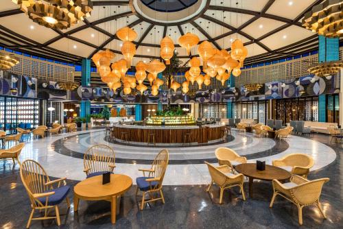 a restaurant with tables and chairs and chandeliers at El Beso Adults Only at Ocean Riviera Paradise All Inclusive in Playa del Carmen