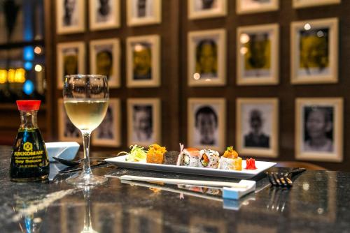 a plate of food and a glass of wine on a table at El Beso Adults Only at Ocean Riviera Paradise All Inclusive in Playa del Carmen