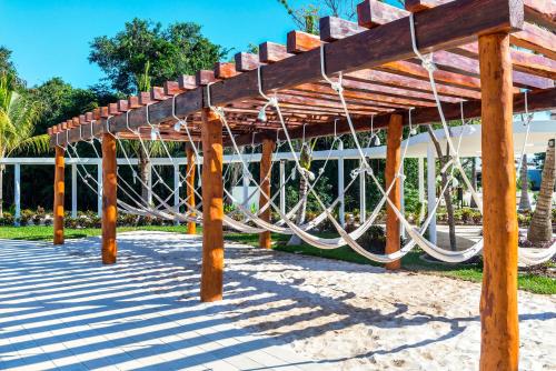 a wooden pergola with ropes hanging from it at El Beso Adults Only at Ocean Riviera Paradise All Inclusive in Playa del Carmen