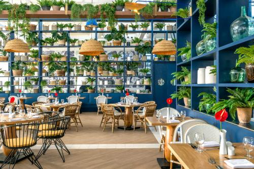 a restaurant with tables and chairs and shelves with plants at El Beso Adults Only at Ocean Riviera Paradise All Inclusive in Playa del Carmen