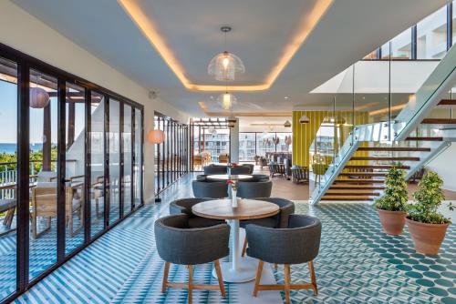 a hotel lobby with chairs and tables and stairs at Ocean Riviera Paradise All Inclusive in Playa del Carmen