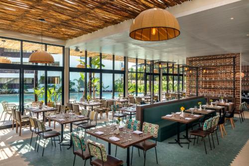 a restaurant with tables and chairs and large windows at Ocean Riviera Paradise All Inclusive in Playa del Carmen
