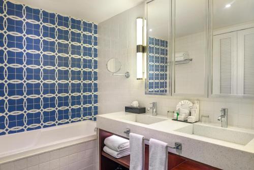 a bathroom with a tub and a sink and a mirror at Ocean Riviera Paradise All Inclusive in Playa del Carmen