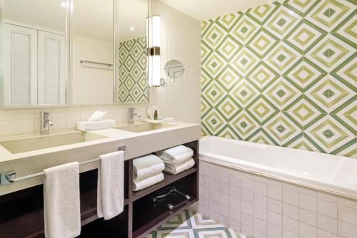 a bathroom with a tub and a sink and a mirror at Ocean Riviera Paradise All Inclusive in Playa del Carmen