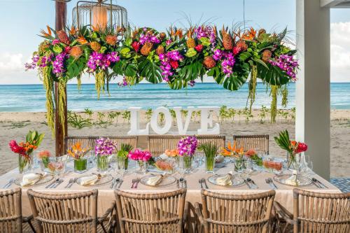 a table at the beach with a sign that reads love at Ocean Riviera Paradise All Inclusive in Playa del Carmen