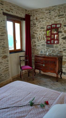 a bedroom with a bed and a dresser and a window at Casa Pablo in Badalucco