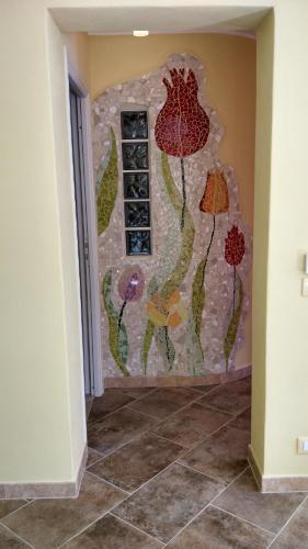 a wall with a window with flowers painted on it at Casa Pablo in Badalucco