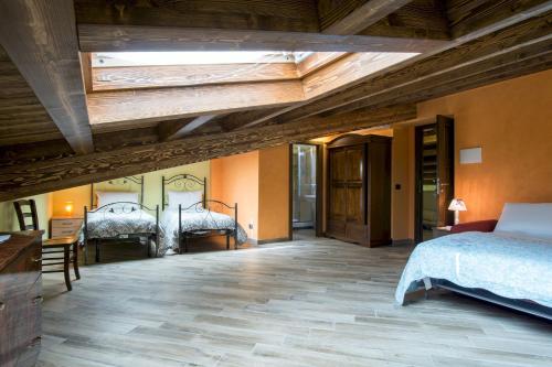 Un dormitorio con dos camas y techo de madera. en L'Arco dei Sogni, en Malvagna