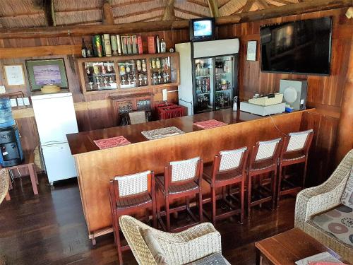 een bar in een restaurant met stoelen en een tv bij River Hill Lodge in Komatipoort