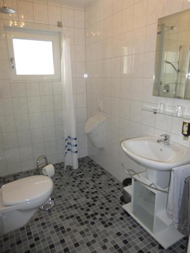 a white bathroom with a sink and a toilet at Ferienwohnung Unica im Lahntal in Villmar