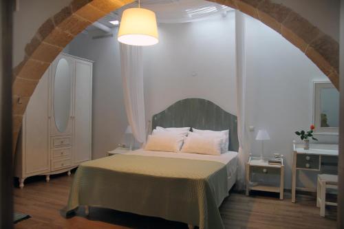 ein Schlafzimmer mit einem Bett in einem Zimmer mit einem Bogen in der Unterkunft Meli-milon in Kolimvárion