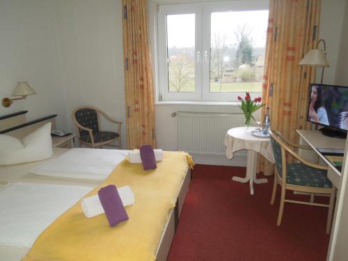 a hotel room with two beds with purple bows on them at Hotel Schnehagen in Bad Fallingbostel