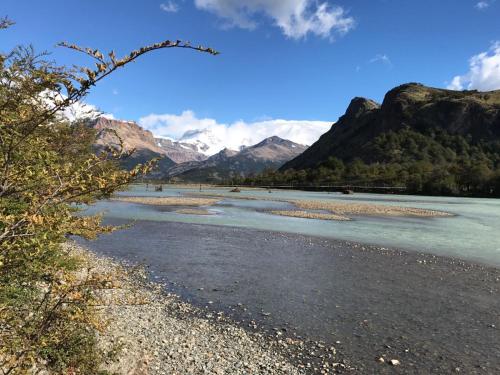 a river with mountains in the background at Camping Rio de las Vueltas in El Chalten