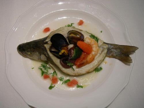 a fish on a plate with vegetables on it at Hotel Mare in Agropoli