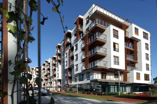 Un edificio alto y blanco con balcones en una calle. en Apartamenty Olimpic, en Kołobrzeg