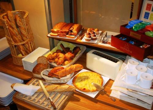un tavolo con diversi tipi di pane e prodotti da forno di Sweet Home a Belley