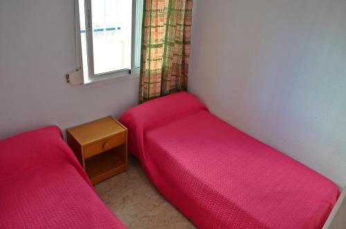 ベナルマデナにあるApartamento Benalmadena Costaのベッド2台と窓が備わる小さな客室です。