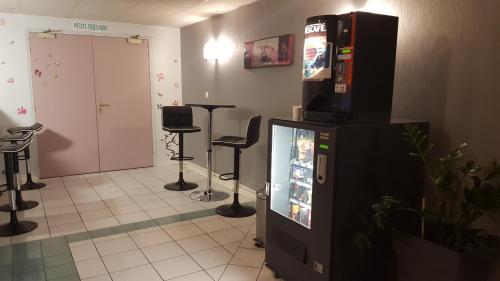 a room with a video game machine and stools at Relax Hotel in Maillat