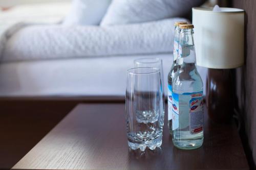 a bottle of water and a glass on a table at Noclegi Prestige in Nowy Sącz