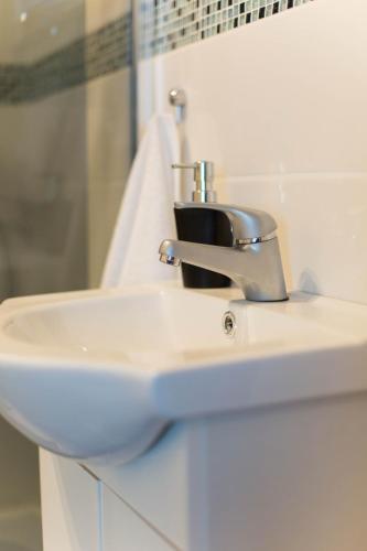 a bathroom sink with a faucet on top of it at Noclegi Prestige in Nowy Sącz