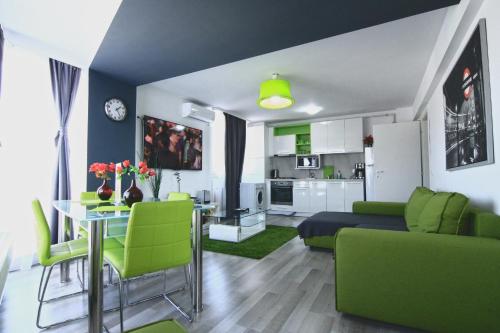 a living room with a couch and a table with green chairs at Dreamtime Apartments in Bucharest