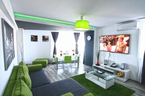 a living room with a green couch and a tv at Dreamtime Apartments in Bucharest