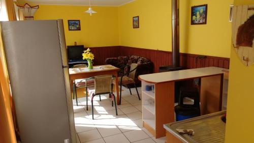 eine Küche mit einem Kühlschrank und einem Tisch im Zimmer in der Unterkunft Cabaña Don Claudio in Osorno