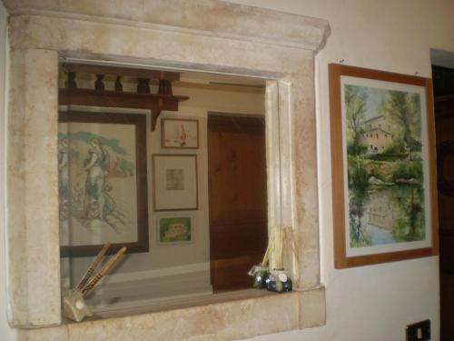 Un espejo en una pared con fotos. en Mulino Della Ricavata, en Urbania