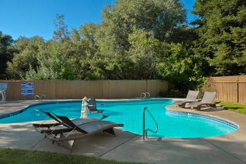 a swimming pool with two lounge chairs next to it at Lake Natoma Inn in Folsom