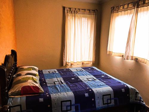 a bedroom with a bed with a quilt on it at Greenhouse Bolivia in La Paz
