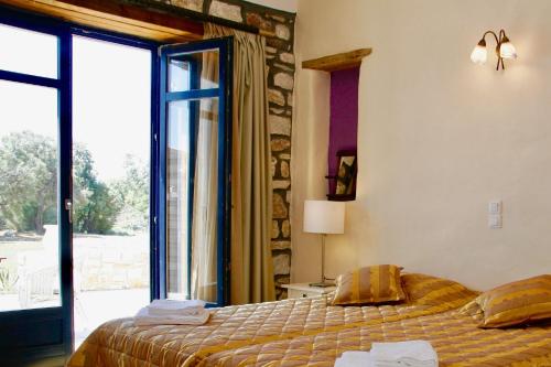 ein Schlafzimmer mit einem Bett und einem großen Fenster in der Unterkunft Porto Paradiso in Chrissi Akti