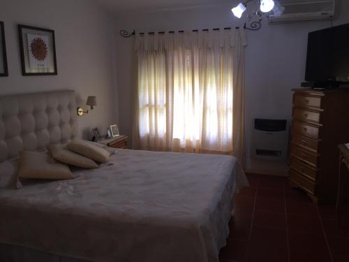 a bedroom with a bed with a dresser and a window at La Maria Josefa in San Rafael