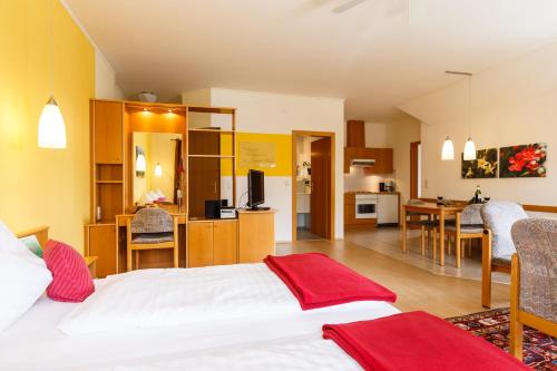 a hotel room with a bed and a kitchen at Landhaus Luka in Mörbisch am See