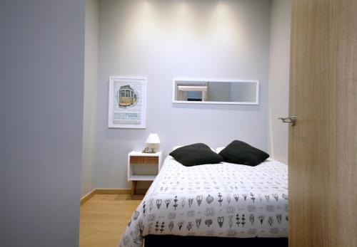 een slaapkamer met een wit bed met zwarte kussens bij Casa da Viola - Faro in Faro