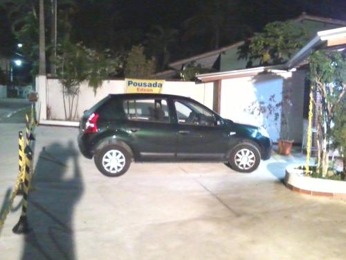 a green car parked in a parking lot at night at Pousada Edson in Caraguatatuba
