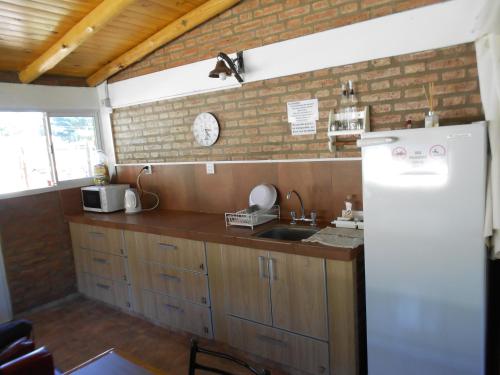a kitchen with a sink and a refrigerator at Complejo Los Gringos in Villa Ciudad de America