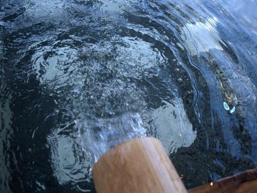 a person standing in the water with a paddle at Hillside Inn Sirocco in Tateyama