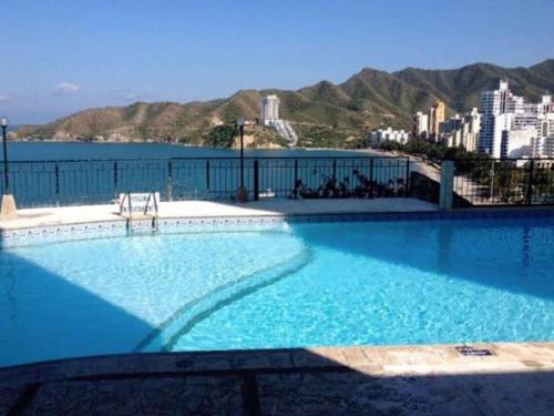 uma grande piscina com vista para a água em El Peñon increible vistas al oceano Torre B em Santa Marta