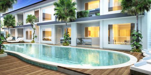 a villa with a swimming pool in front of a building at Coast Boutique Hotel in Kuta