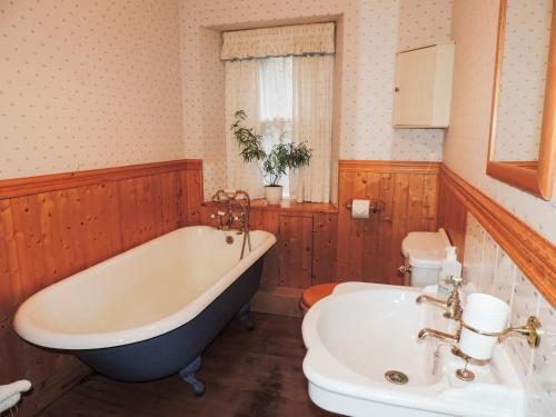 ein Badezimmer mit Badewanne, Toilette und Waschbecken in der Unterkunft Springburn Cottage in Strachur