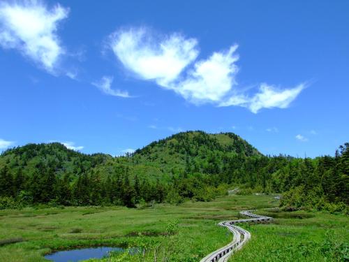 a winding river in a field with a mountain at Hotel Japan Shiga in Yamanouchi