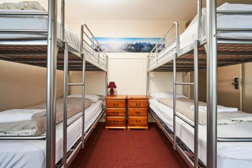 sypialnia z 2 łóżkami piętrowymi i komodą w obiekcie Abom Hotel w mieście Mount Buller
