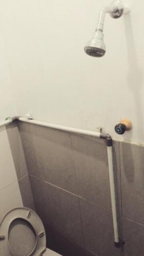 a bathroom with a toilet with a light above it at Pari Solata Seaview Homestay Syariah in Kepulauan Seribu