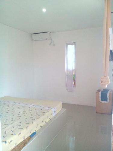 a white room with a bed and a window at Pari Solata Seaview Homestay Syariah in Kepulauan Seribu