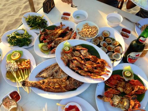 a table with many plates of food on it at Pari Solata Seaview Homestay Syariah in Kepulauan Seribu