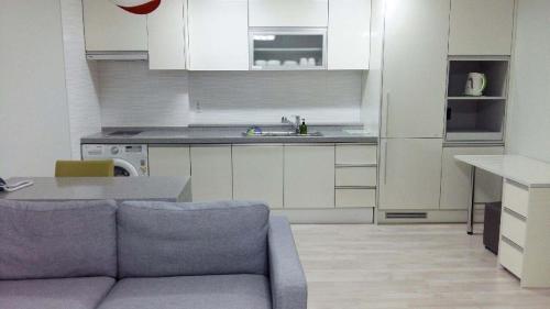 a living room with a couch and a kitchen at Gaon Residence Hotel in Daejeon