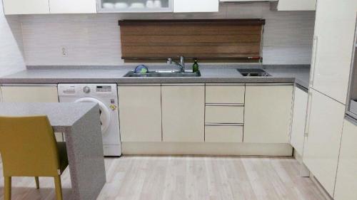 a small kitchen with a sink and a dishwasher at Gaon Residence Hotel in Daejeon
